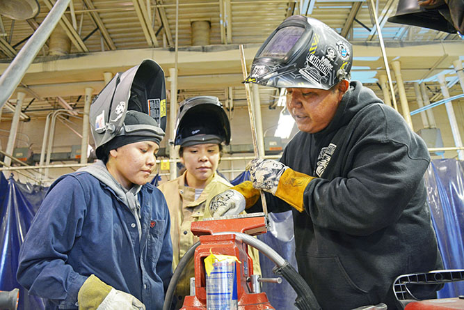In this November 2022 file photo, UNM-Gallup Visiting Lecturer II Casey Tom works with two welding students during class in Gurley Hall.