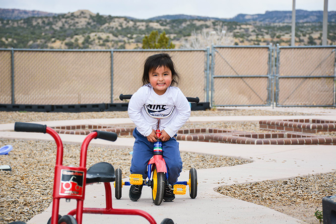 Kent Kayonnie, 3, rides a tricycle around the playground at Bright Futures Daycare, which is located on The University of New Mexico-Gallup campus, on May 1, 2025.