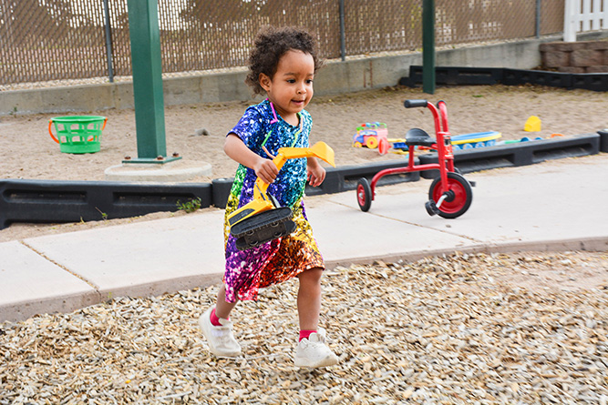 Zuri Duran, 3, runs while playing with a toy excavator on the playground at Bright Futures Daycare, which is located on The University of New Mexico-Gallup campus, on May 1, 2025.