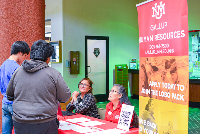 UNM-Gallup Human Resource administrator 2 Yatisha Yoe and HR tech Wilma Lee speak to two students during the Spring 2025 Job Fair in Gurley Hall on Wednesday, May 14, 2025.