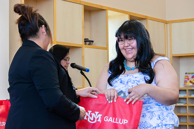 Medical Laboratory Technology Program Director Lucia Guerrero, left, presents Adult Basic Educaton student Eisha Spencer with a swag bag and cookie during a graduation ceremony in Zollinger Library at The University of New Mexico-Gallup on April 28, 2026.