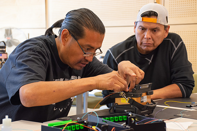 Students Michael Notah, left, and Brian Yazzie work on a fusion splicing exercise during the Fiber Optic Bootcamp at The University of New Mexico-Gallup on Friday, June 12, 2026.