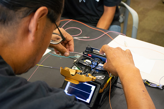 Student Michael Notah works on a fusion splicing exercise during the Fiber Optic Bootcamp at The University of New Mexico-Gallup on Friday, June 12, 2026.