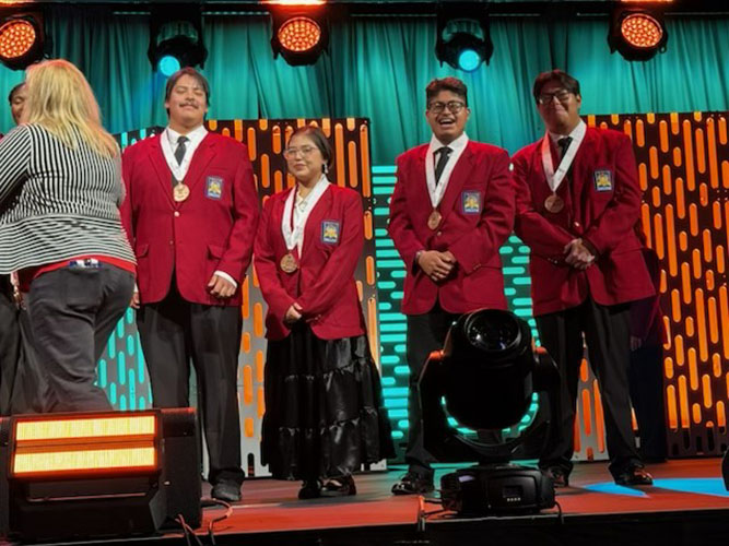 In this courtesy photo, UNM-Gallup SkillsUSA Chapter members (from left) Collin Brieno, Layla Perry, Donovan Padilla and Sonny Gene accept their bronze medals on stage at the SkillsUSA National Leadership & Skills Conference in Atlanta on June 5, 2026.