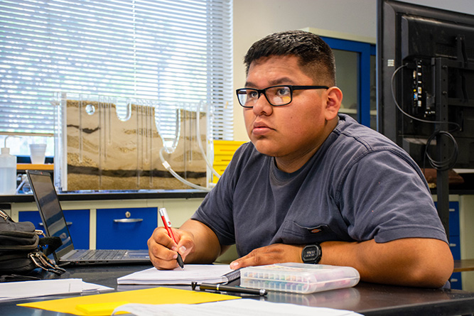 Student Xavier Skeet takes notes in an environmental science class titled The Blue Planet in Calvin Hall Center at The University of New Mexico-Gallup on Wednesday, Aug. 19.