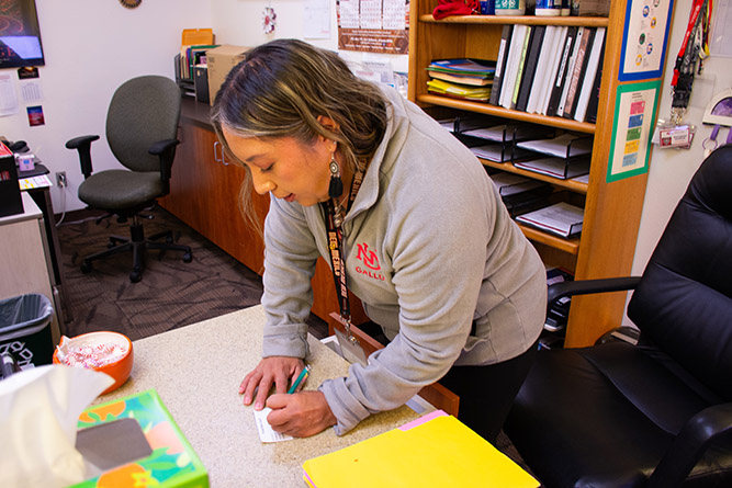 Accommodations Specialist Shana Arviso assists a student receiving a weekly food box inside the Student Resource Center at The University of New Mexico-Gallup on Tuesday, Oct. 6, 2026.
